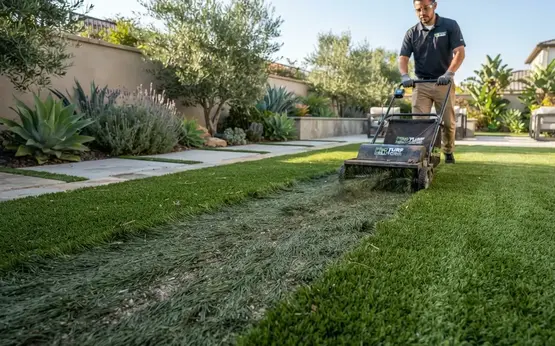 Professional artificial turf maintenance correcting flattened fibers, drainage issues, and restoring synthetic grass