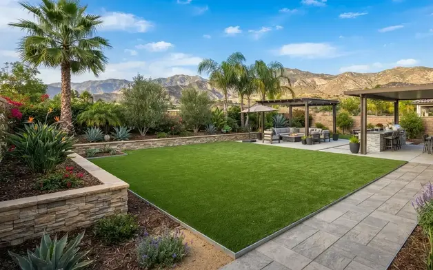 Luxury Southern California backyard featuring professionally installed artificial turf, decorative pavers, retaining walls, and drought-tolerant landscaping in the Inland Empire