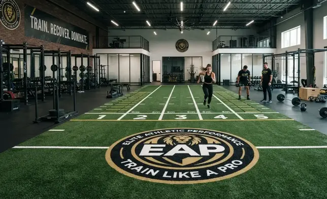 Custom branded gym turf design with performance markings inside a fitness facility