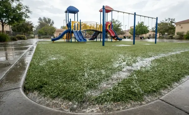 Playground turf draining water quickly after rainfall in an Inland Empire school with dry safe surface and no standing water