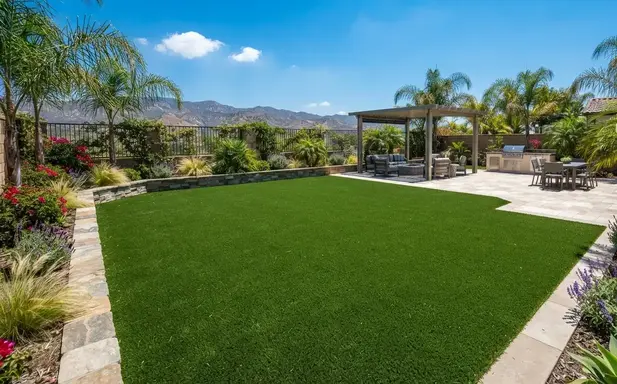 Luxury Inland Empire backyard featuring a professionally installed artificial turf landscape with seamless hardscape integration and a level engineered foundation